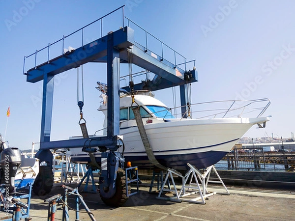 Obraz motorboat yacht  in shipyard  for repair and maintenance in marina port