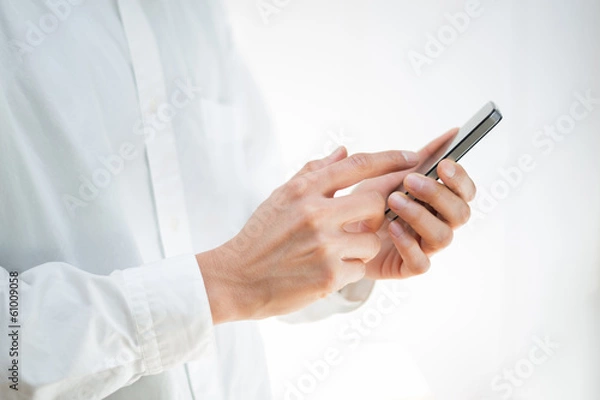 Fototapeta Close-up image of a man using a mobile smartphone
