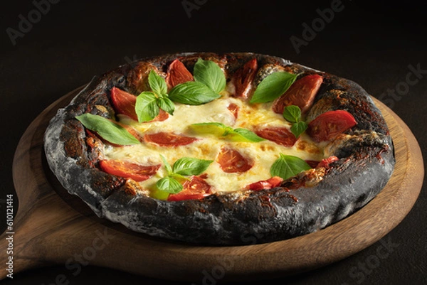 Fototapeta Black pizza margarita with tomatoes, mozzarella and basil. Dough with healthy bamboo charcoal powder