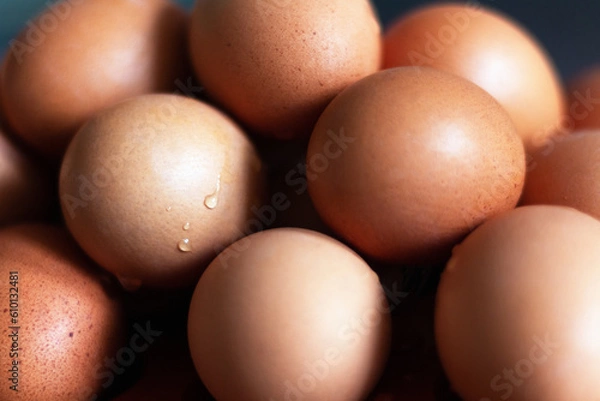 Fototapeta Stacked colored eggs sprayed with water in close up