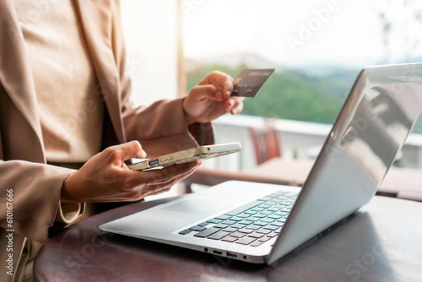 Fototapeta Closeup of businesswoman using mobile phone while holding credit card, Female shopping online or booking ticket. New normal lifestyle and cashless society, internet banking concept. copy space