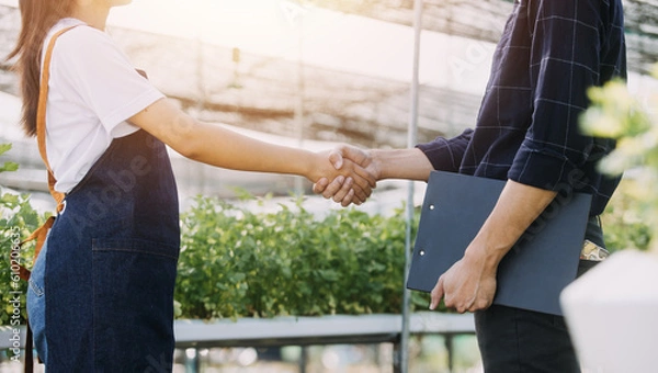 Fototapeta Farmer man and woman using laptop examing quality at vegetable hydroponic at greenhouse. Concept of vegetables health food. Smart farm using technology growing business hydro produce.