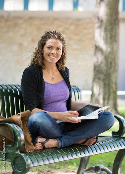 Fototapeta Portrait Of Happy Student Studying On Bench