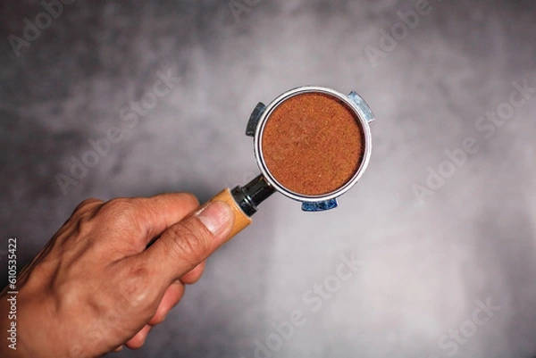 Fototapeta Hands hold portafilter with ground coffee for espresso coffee maker 