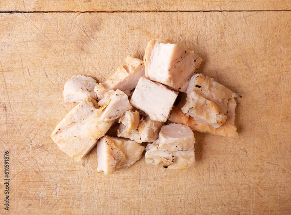 Obraz Top view of several pieces of roasted chicken breast on wood cutting board.