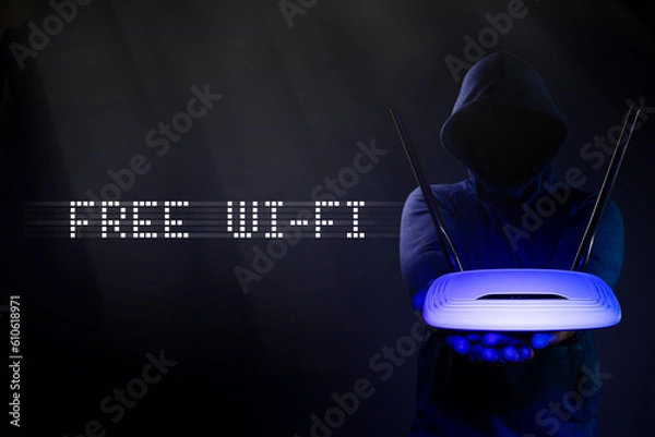 Fototapeta Free Wi-Fi. Hacker is holding a router in his hands.  Vulnerabilities in wireless internet.
