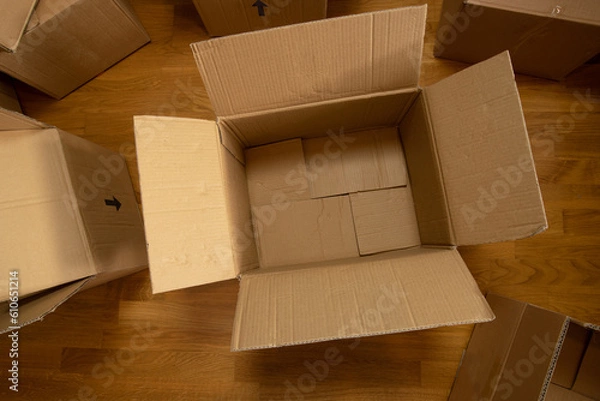 Fototapeta An empty cardboard box on the floor. Packing for moving. Box for logistics.