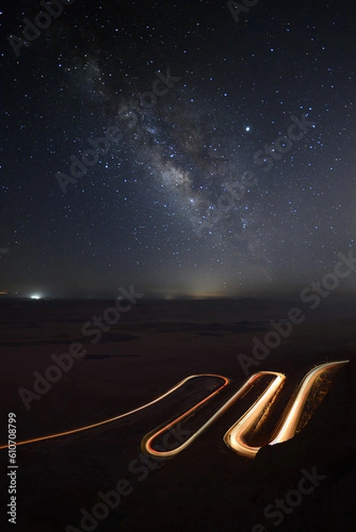 Obraz the milky way over a curvy road with light trails of a car  near Mizpe Ramon - Israel 