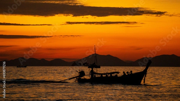 Fototapeta Sunset in the sea with a boat, in Ao Nang, Thailand.