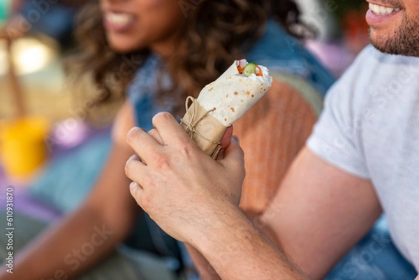 Obraz man is holding a burrito in his hand