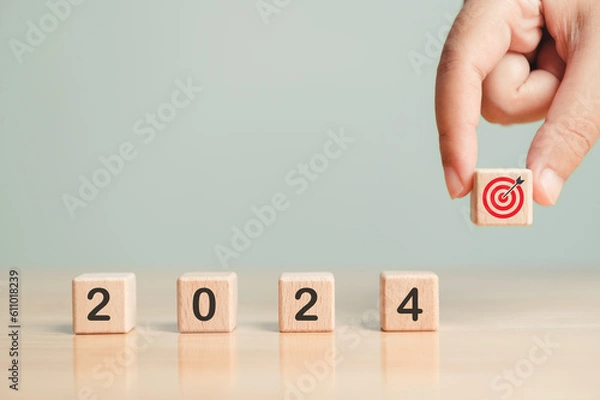 Fototapeta 2024 text New year future target plan setting wooden blocks businessman hand placing red goal dartboard symbol. Business agenda mission setting concept. Dart board cube future vision strategy success