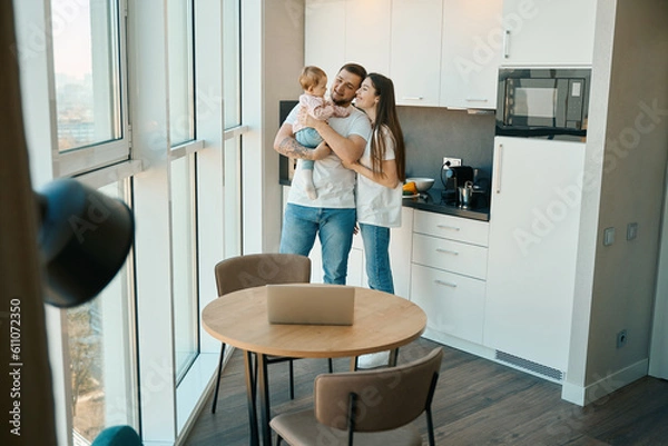 Fototapeta Loving parents pamper a little child at home