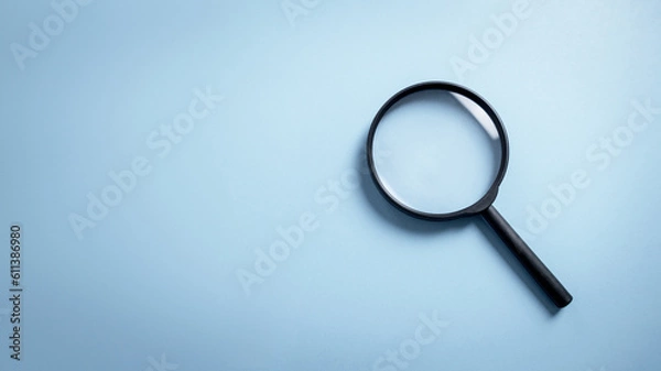 Fototapeta Top view empty lens black magnifying glass on white blue pastel background. Flat lay object and inspection investigate science equipment tool concept. Police and Ciencia forense theme. Copy space.