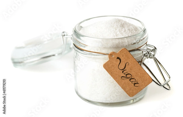 Fototapeta Opened glass jar with sugar. Isolated on white.