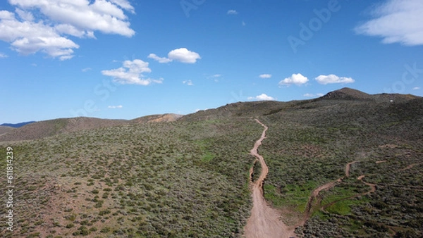 Fototapeta OHV area with rutted paths going up into green mountains