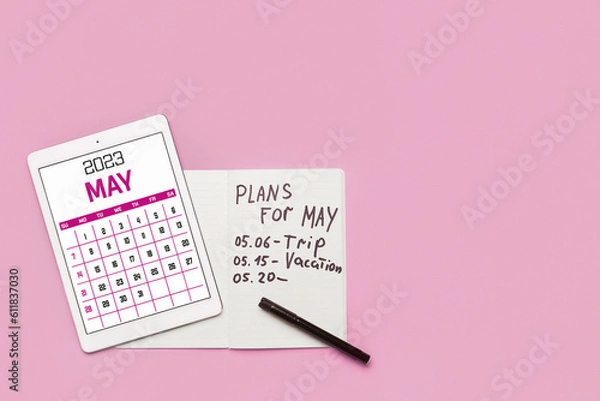Obraz Modern tablet computer with calendar and notebook with plans for May on pink background