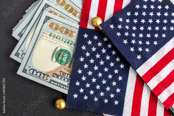 Fototapeta American flags with dollar bills on black background.