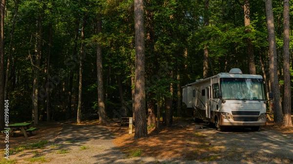 Obraz Rv motorhome parked at campsite with tall trees in forest