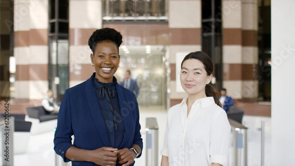 Fototapeta Portrait of two successful and ethnically diverse colleagues smiling to camera