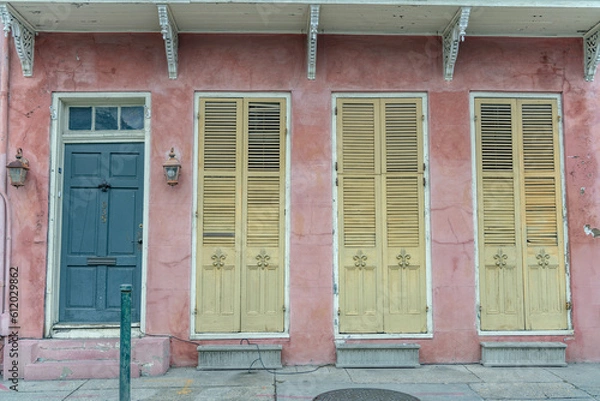 Obraz Beautiful home exterior in the French Quarter in New Orleans, Louisiana. Shallow focus for artistic effect on the fleur de lis on the left-most yellow shutter.