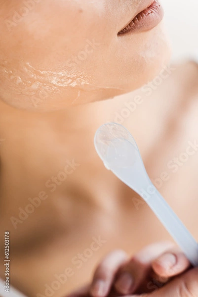 Fototapeta Close-up applying carboxy co2 gel on face of girl. Carboxtherapy procedure with carbon dioxide for wrinkle smoothing, facelift, and skin hydration, normalization of hydro-lipid balance.