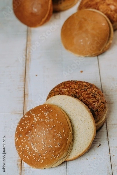 Fototapeta Vertical of the freshly baked and sliced bun breads put on the white table surface