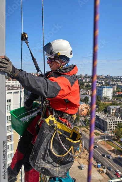 Fototapeta Rope access. Cleaning the windows of the skyscraper.