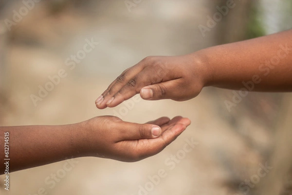 Fototapeta Two boys are holding one another's hand and the background is blurred behind them