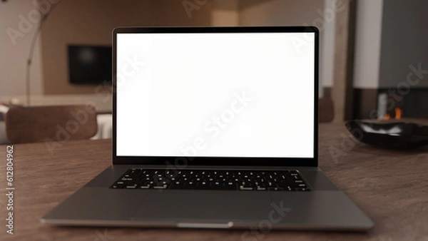 Obraz close up of a laptop on a table in a modern living room with transparent screen for content placement like Mockups, Home Office Commercial, Advertising or Infographics.