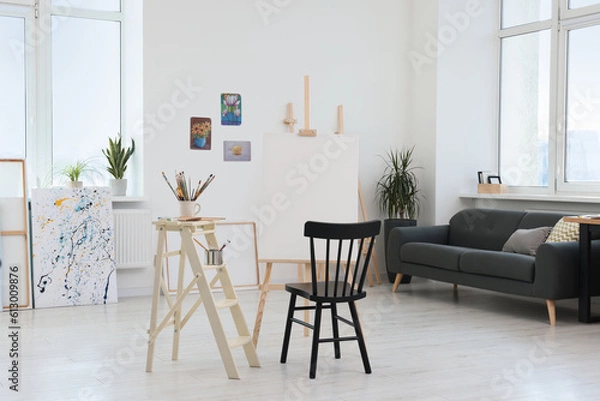 Fototapeta Studio with chair, easel and canvas. Artist`s workspace