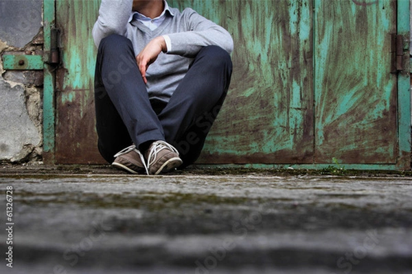 Obraz The man sitting on the ground