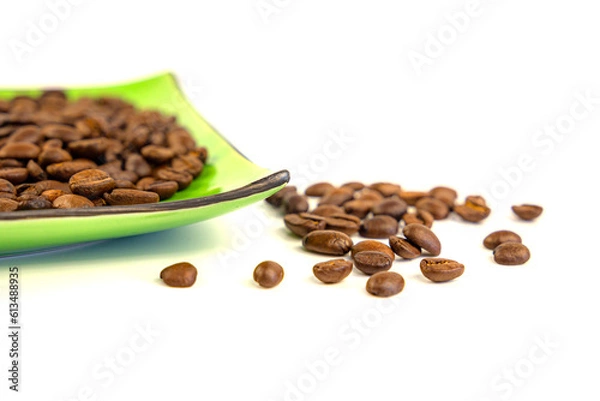 Fototapeta Coffee beans on a green square saucer, white background
