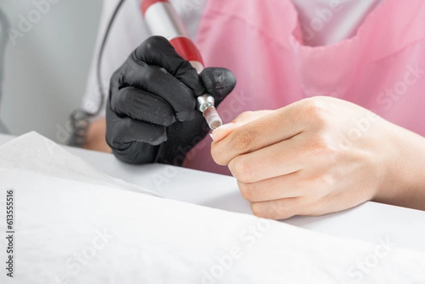 Obraz close-up of a latina woman's hands using an electric polisher to polish her nails