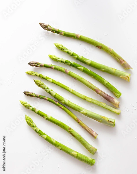 Fototapeta Top view crisp green asparagus on white table. Asparagus bundle in row. Vegetable pattern. Copy space.