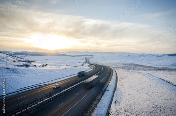 Obraz Highway road over the mountains with speeding cars and trucks on