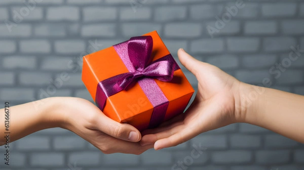 Fototapeta Close up hands exchanging a gift, orange gift with purple ribbon, offering a gift, pretty gift, offering a gift to someone, made with generative AI