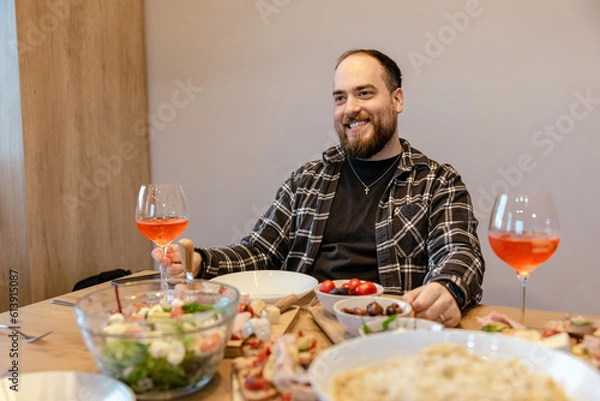 Fototapeta A smiling handsome man having a culinary experience