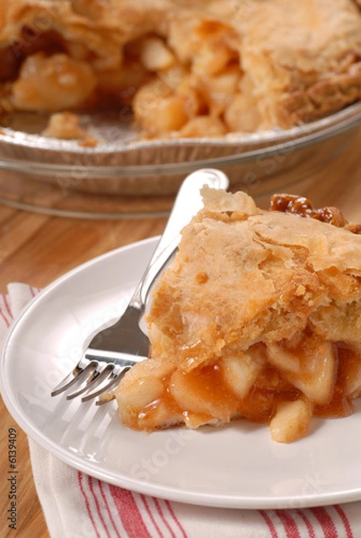 Fototapeta A slice of a deep dish apple pie with a flaky crust