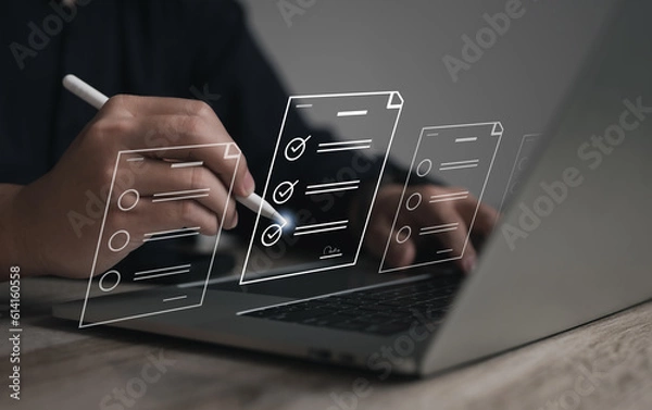 Fototapeta Performance checklist concept : businessman using stylus pen with laptop for questionnaire, evaluation, assessment online or survey exam and filling out for digital survey and checklist..