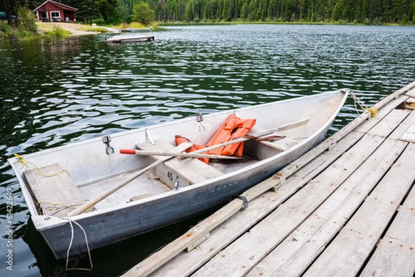 Fototapeta Old Row Boat  with Lifejackets Moored to Dock in Lake