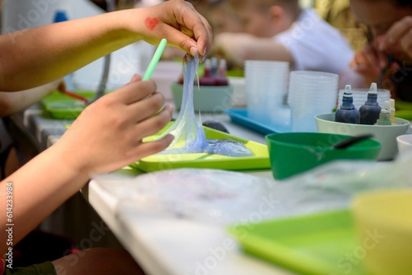 Obraz A young hand draws clear mucus from a cup. Chemical experiments.