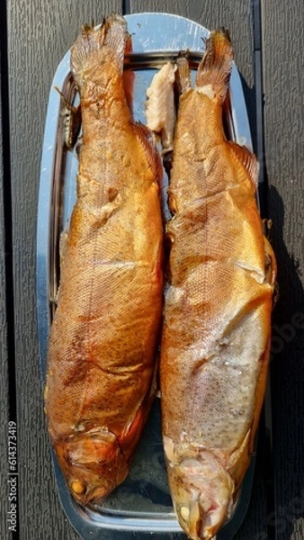 Fototapeta Two grilled trout fishes on a plate