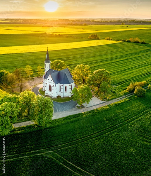 Fototapeta biały kościół wśród pól i zielonych łąk
