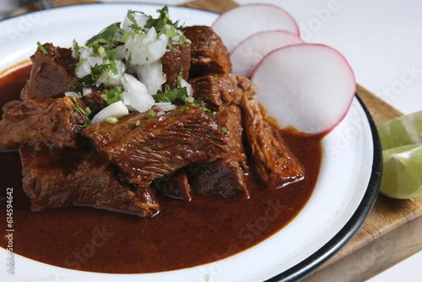Obraz A plate of beef birria tacos with a red sauce and radishes