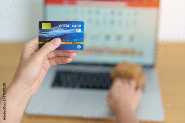 Obraz woman hand holding credit card and using laptop with mobile phone for online shopping while making order. Marketplace platform website, technology, ecommerce, shipping delivery and online payment