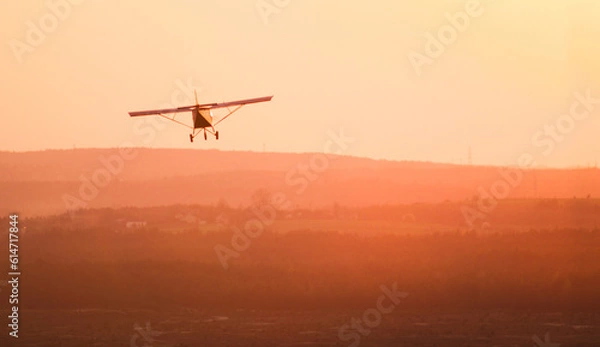 Fototapeta airplane landing at sunset