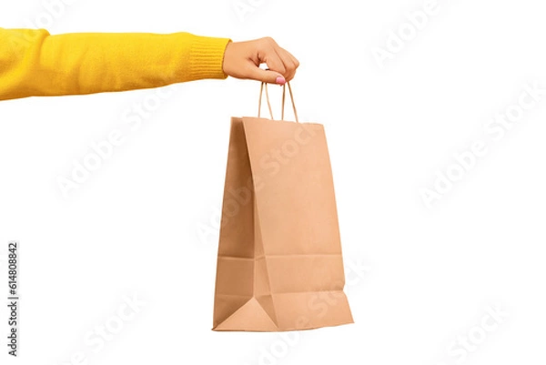 Fototapeta Woman hand holding paper shopping bag isolated on transparent background. Discounts and sale of concept.