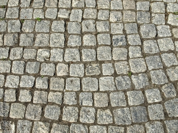Fototapeta Fragment of a pavement made of roughly processed stones