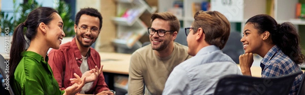 Obraz Creating success. Group of young happy multi racial business people communicating and sharing ideas while working together in the modern office