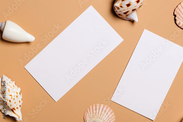 Fototapeta Gently beige background, white paper cards A4, A6, business cards and flyers for the company, beauty industry. Soft background, sea and river shells. Generative AI